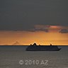 cruise ship passes sunset between venezuela mountain and curacao coast